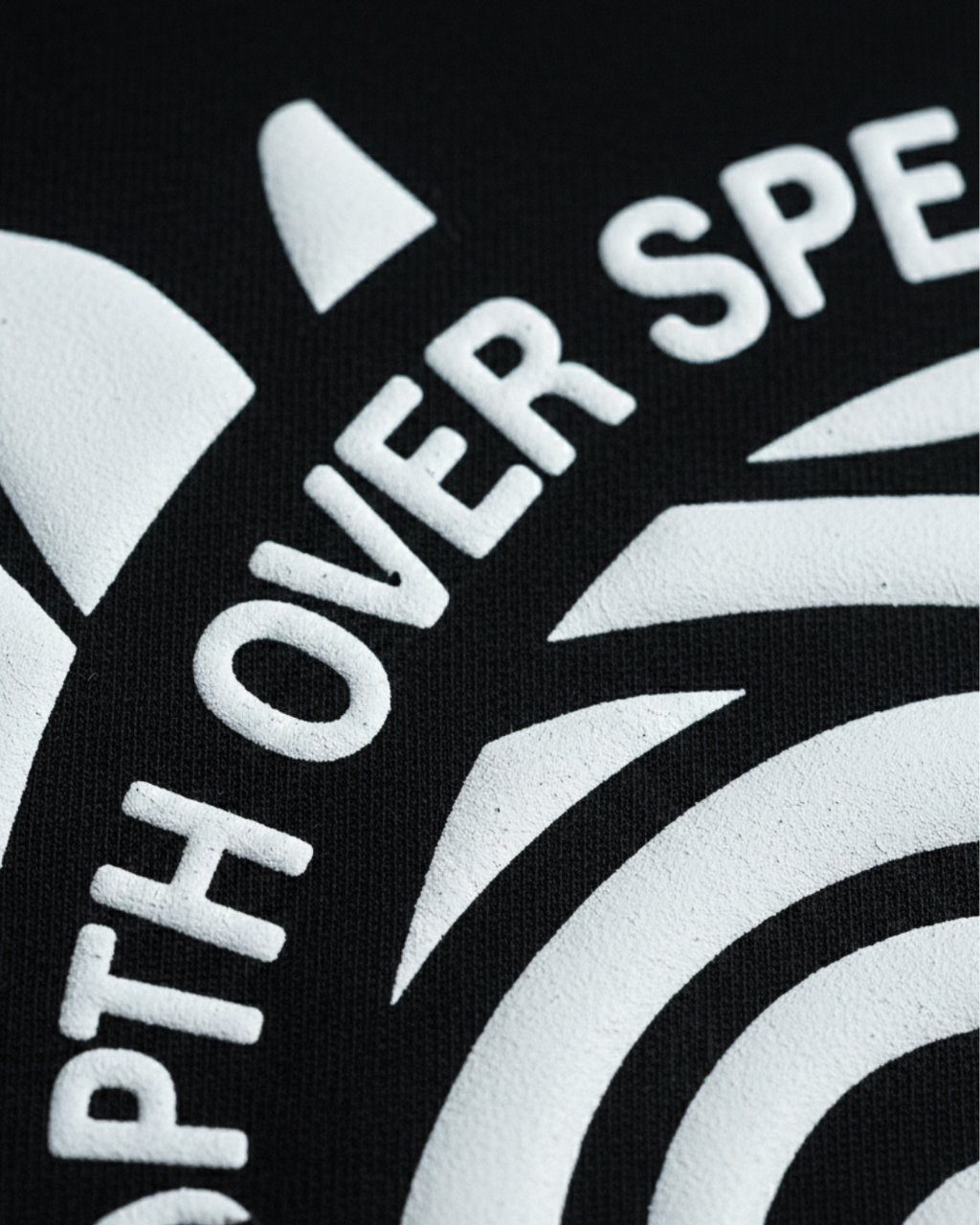 Close-up of a logo with 'DEPTH OVER SPEED' text on a black background